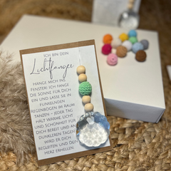 Suncatcher Lichtfänger in Geschenkverpackung. Eine Karte mit wundervollem Text und dem Anhänger mit Kristallkugel, grüner Häkelperle und Holzperlen.