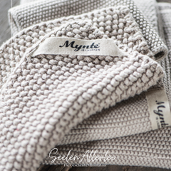 Topflappen Mynte von IB Laursen aus gestrickter Baumwolle liegt auf gleichfarbigen Spültüchern