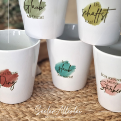 Porzellantasse mit Affirmationen auf buntem Hintergrund zur Individualisierung