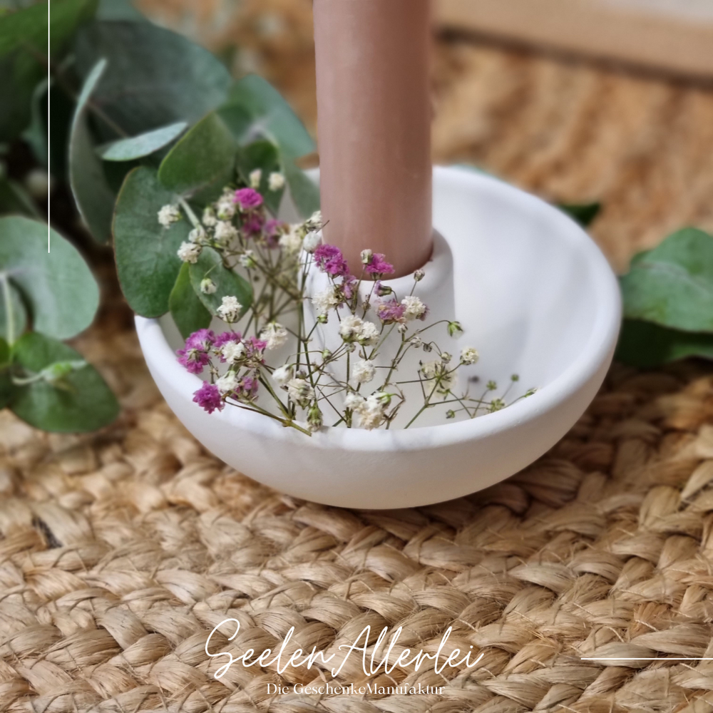 Raysin Kerzenhalter in weiß mit einer farbigen Kerze und Schleierkrautdekoration