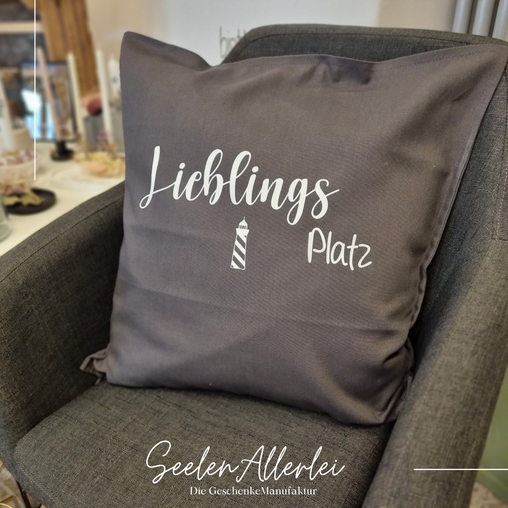 Kissen mit der Aufschrift "Lieblingsplatz" liegt auf einem Stuhl im Ladenlokal