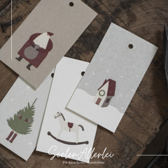 Detailaufnahme von 4 der Geschenkanhänger, die auf einem Holztisch liegen