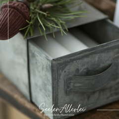 Detailaufnahme der Schublade gefüllt mit weißen Kerzen.