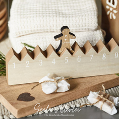 Wander Adventskalender aus Holz in Hausoptik mit einem laufenden Lebkuchenmann und den Zahlen von 1-24