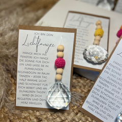 Suncatcher Lichtfänger in Geschenkverpackung. Eine Karte mit wundervollem Text und dem Anhänger mit Kristallkugel, pinker Häkelperle und Holzperlen.