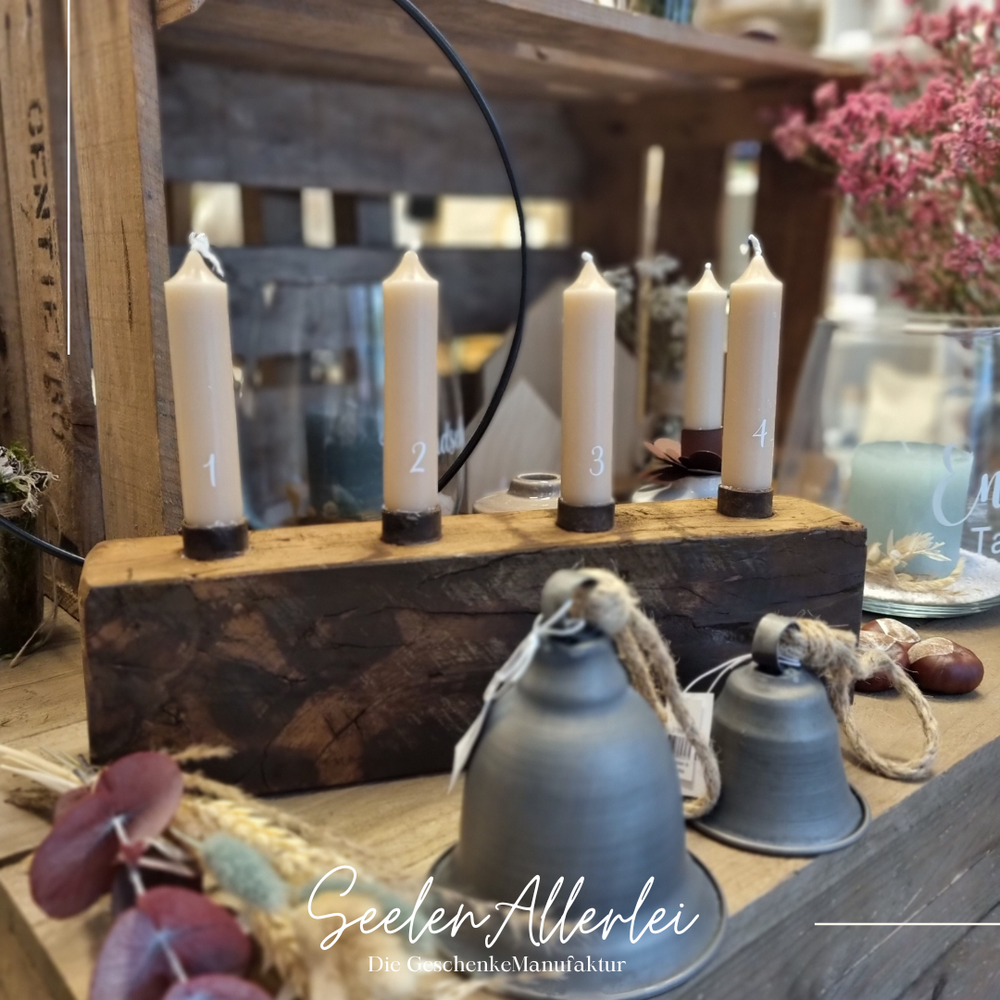Metallglocken von IBLaursen stehen vor einem Adventsgesteck mit 4 Kerzen