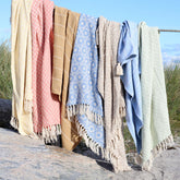 7 Decken von der Firma Chic Antique hängen zum Anschauen auf einem Seil drappiert als Beispielbild für die Auswahl der Farben.