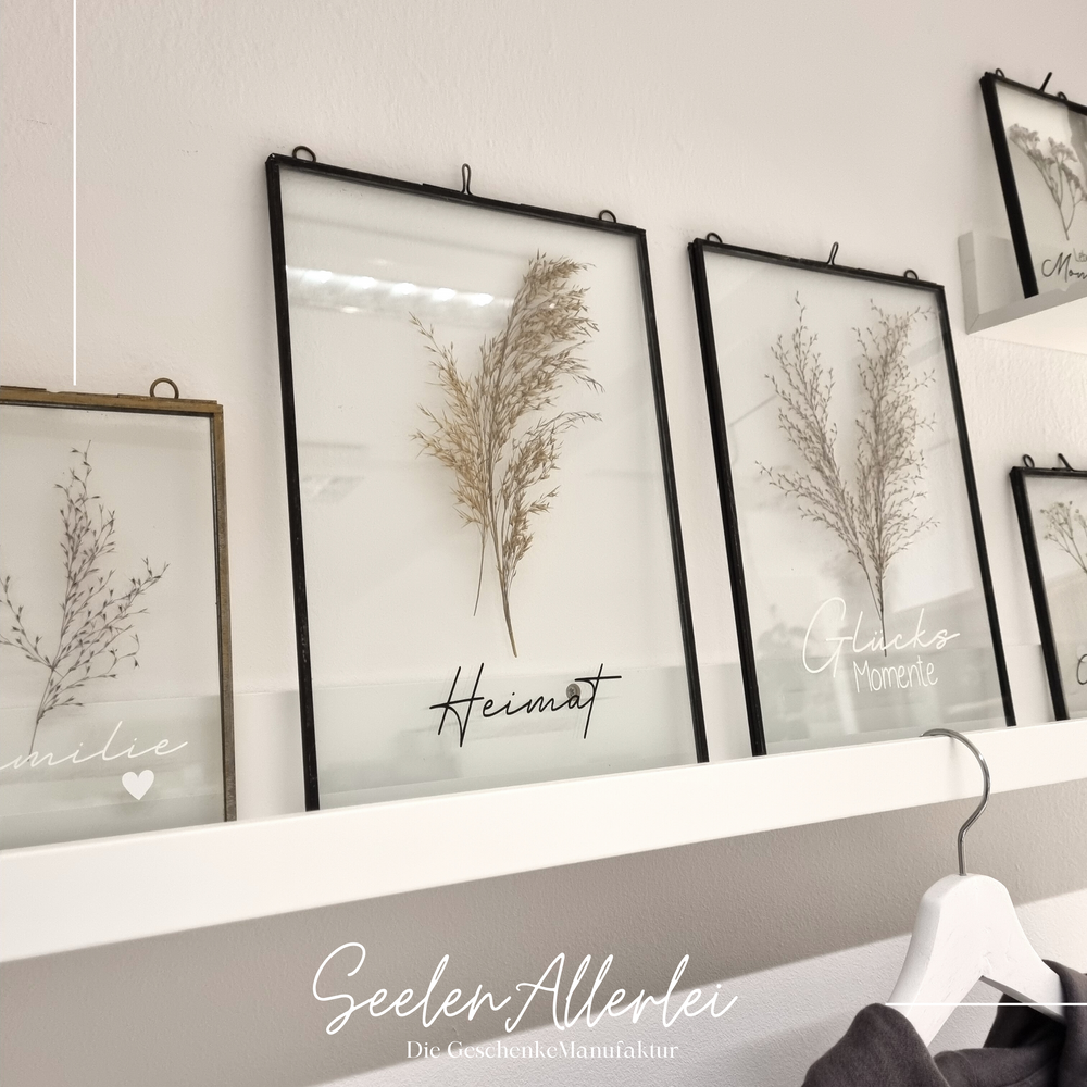 Glasrahmen von iblaursen in unterschiedlichen Größen auf einer bilderleiste mit unterschiedlichen Sprüchen wie Heimat, Glücksmomente oder Erinnerungen