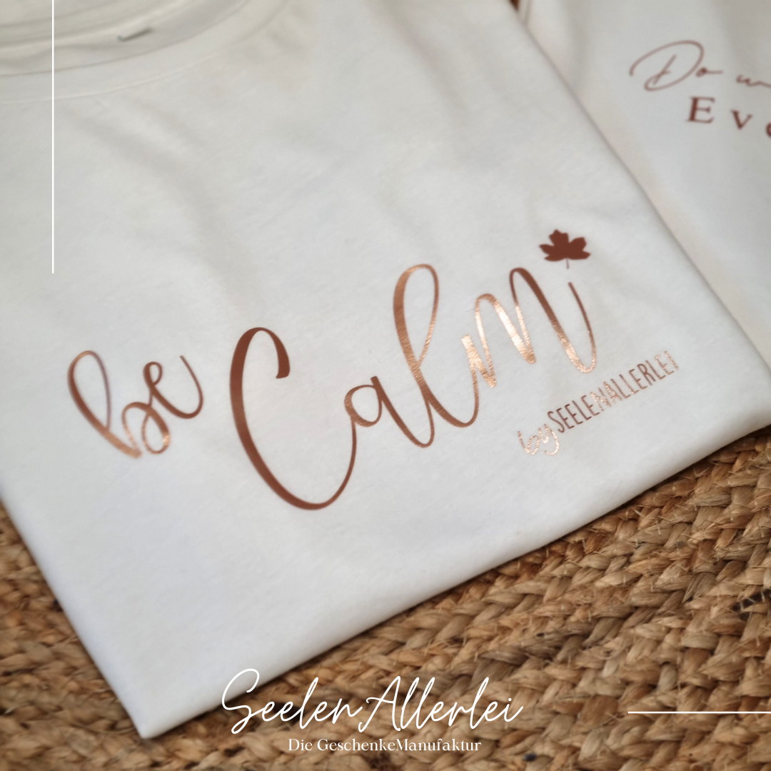 Be calm steht auf einem weißen T-shirt neben einem anderen Tshirt