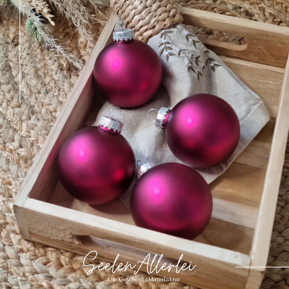 pinke satinierte Baumkugeln aus Glas in einem Tablett