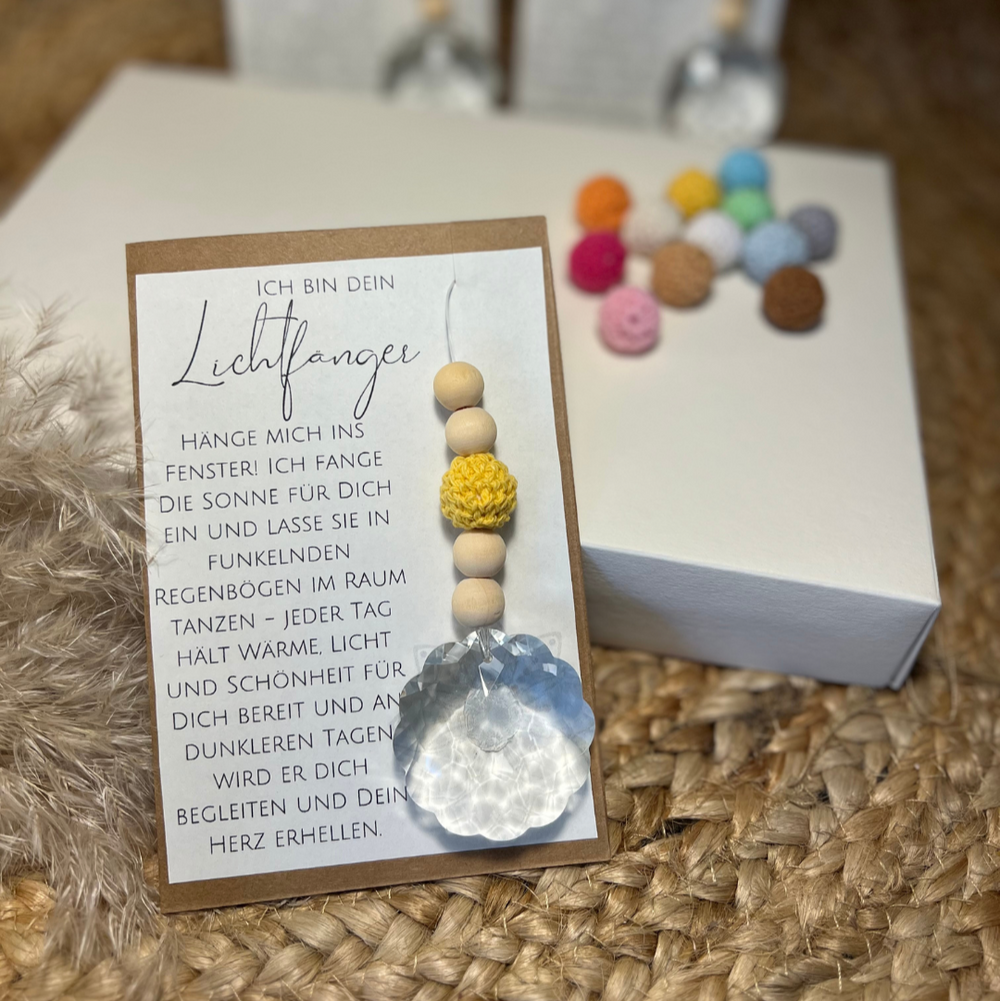 Suncatcher Lichtfänger in Geschenkverpackung. Eine Karte mit wundervollem Text und dem Anhänger mit Kristallkugel, gelber Häkelperle und Holzperlen.
