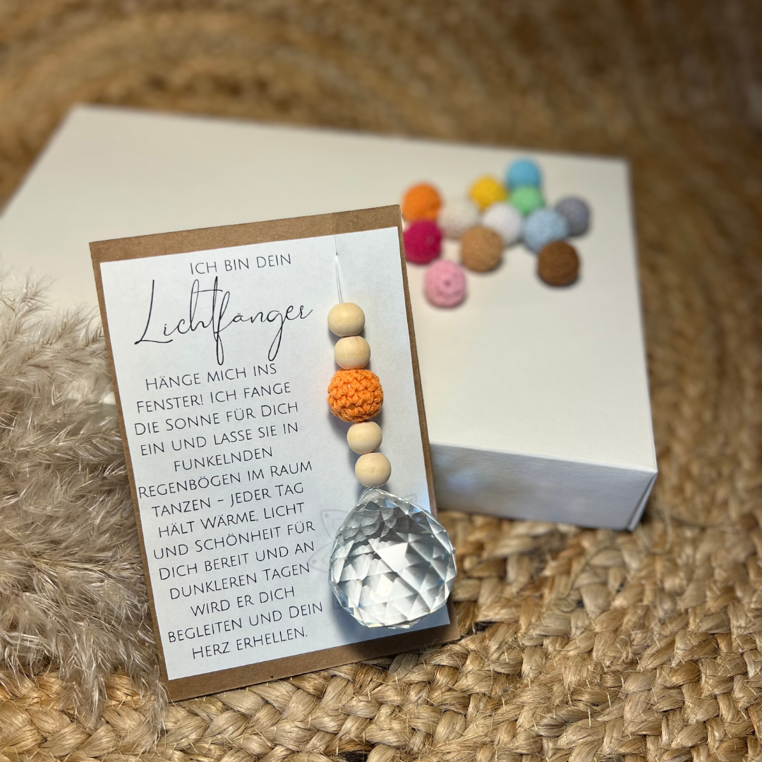 Suncatcher Lichtfänger in Geschenkverpackung. Eine Karte mit wundervollem Text und dem Anhänger mit Kristallkugel, orangefarbene Häkelperle und Holzperlen.