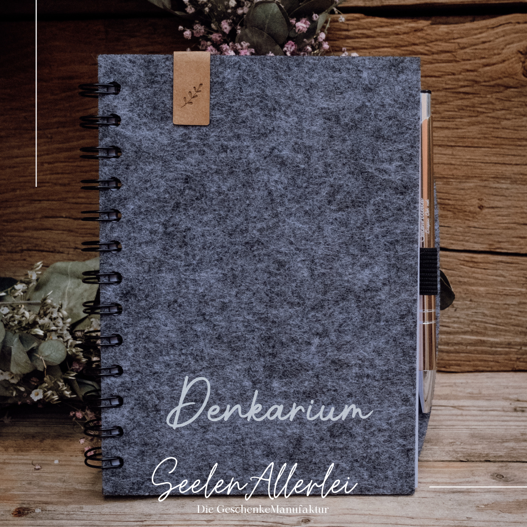 Denkarium steht auf einem Notizbuch 