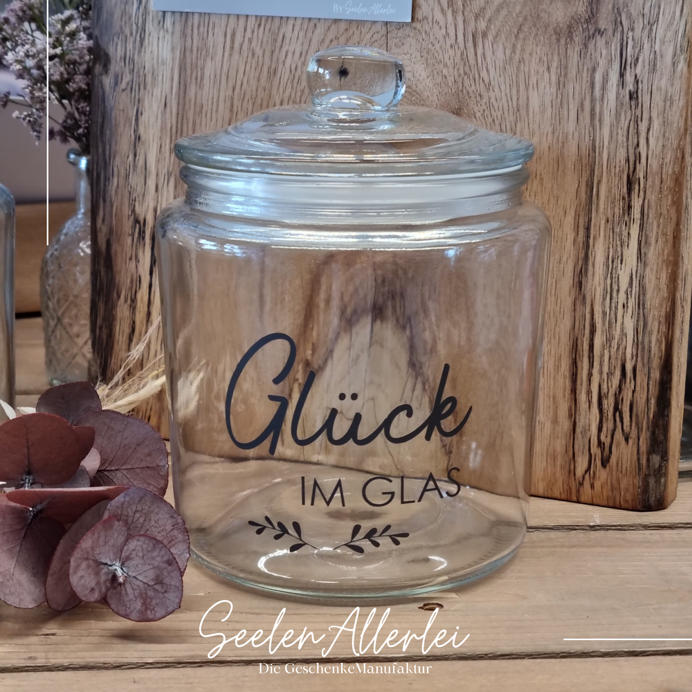 Glasaufbewahrung von IBLaursen mit der Aufschrift Glück im Glas steht auf einem holztisch - es ist leer