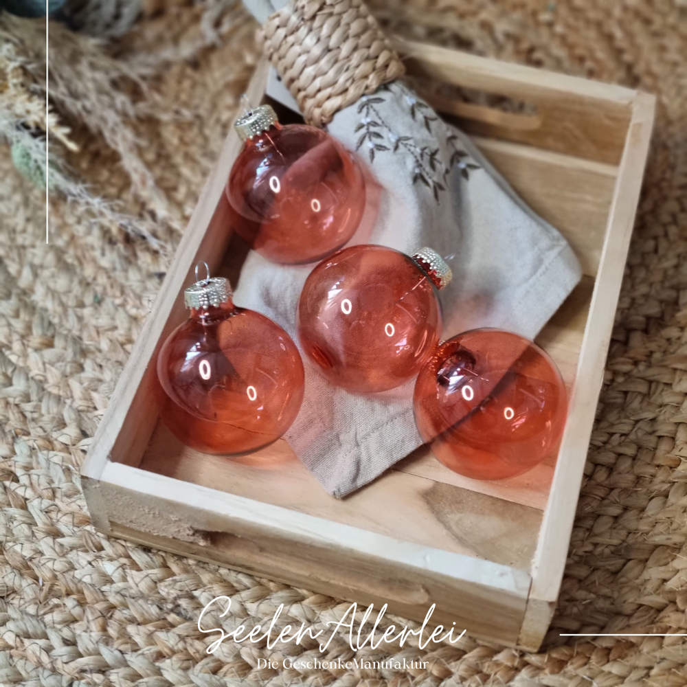 kupferfarbene durchsichtige Weihnachtsbaumkugeln liegen in einem Tablett