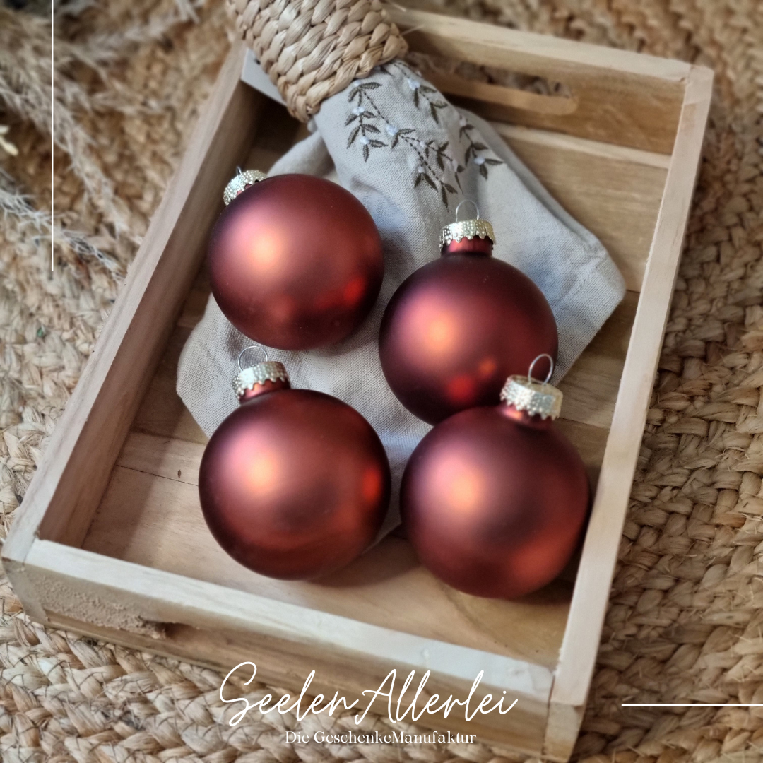 satinierte Kupferfarbene Weihnachtsbaumkugeln liegen auf einem Tablett
