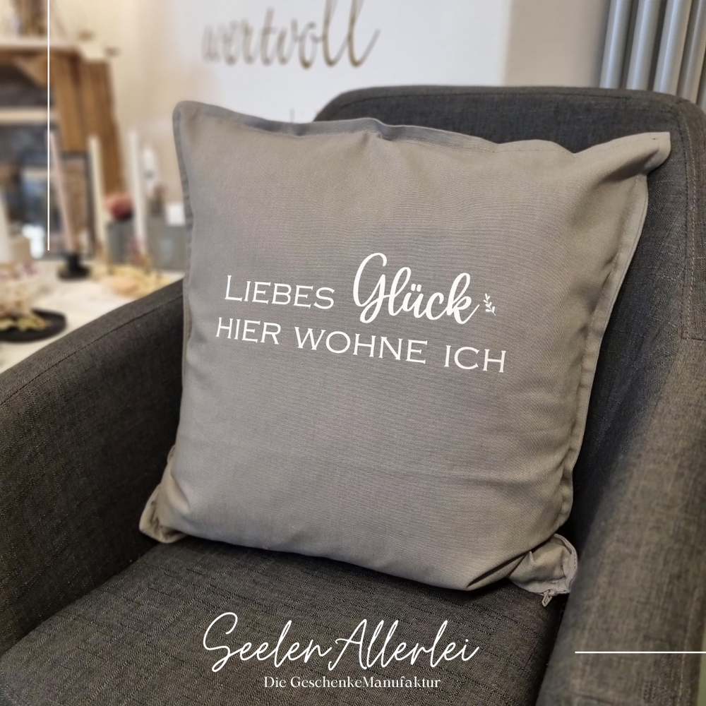 "Liebes Glück, hier wohne ich" Spruch auf einem Kissen 