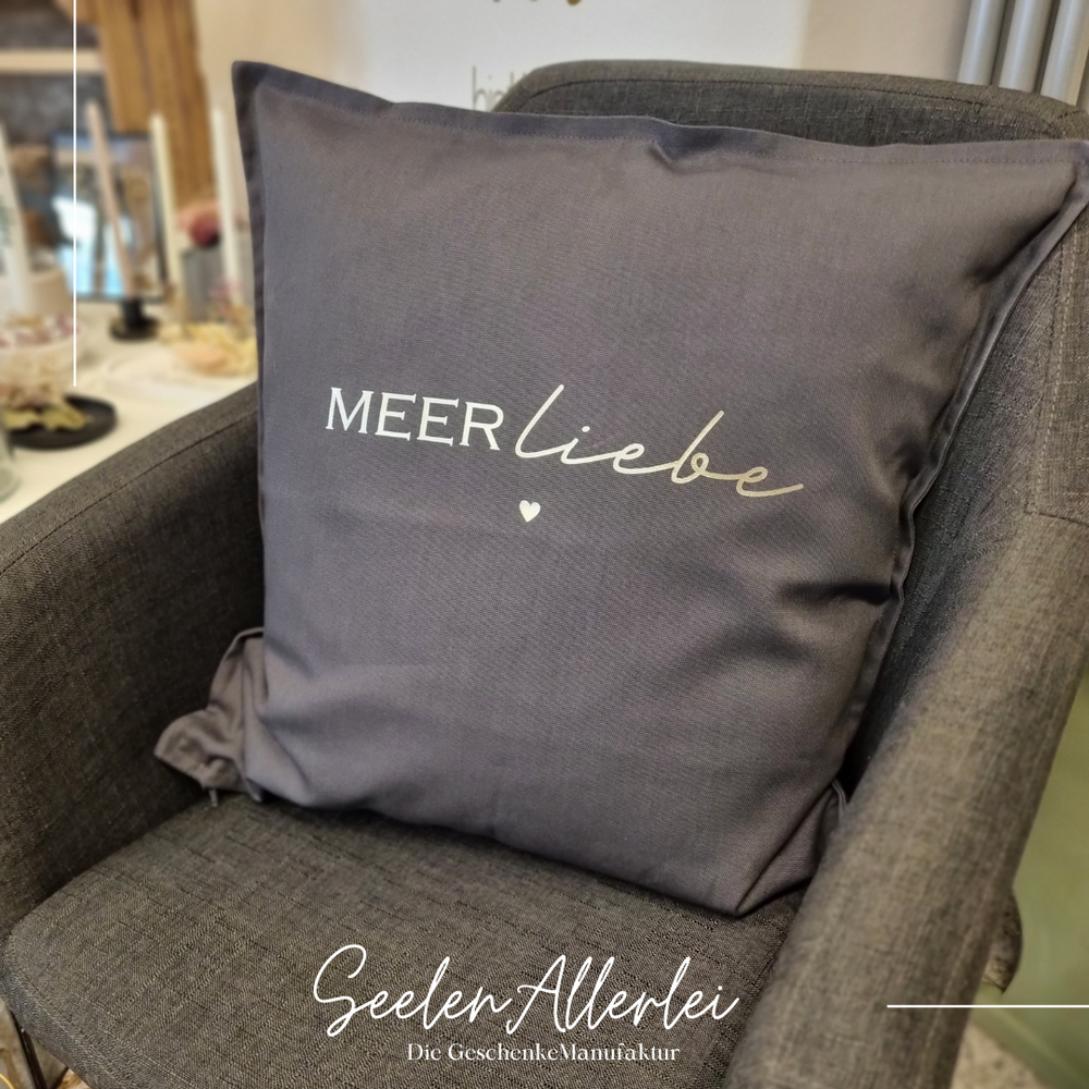 Meerliebe steht auf einem gefüllten Kissen, dass auf einem Sessel liegt.