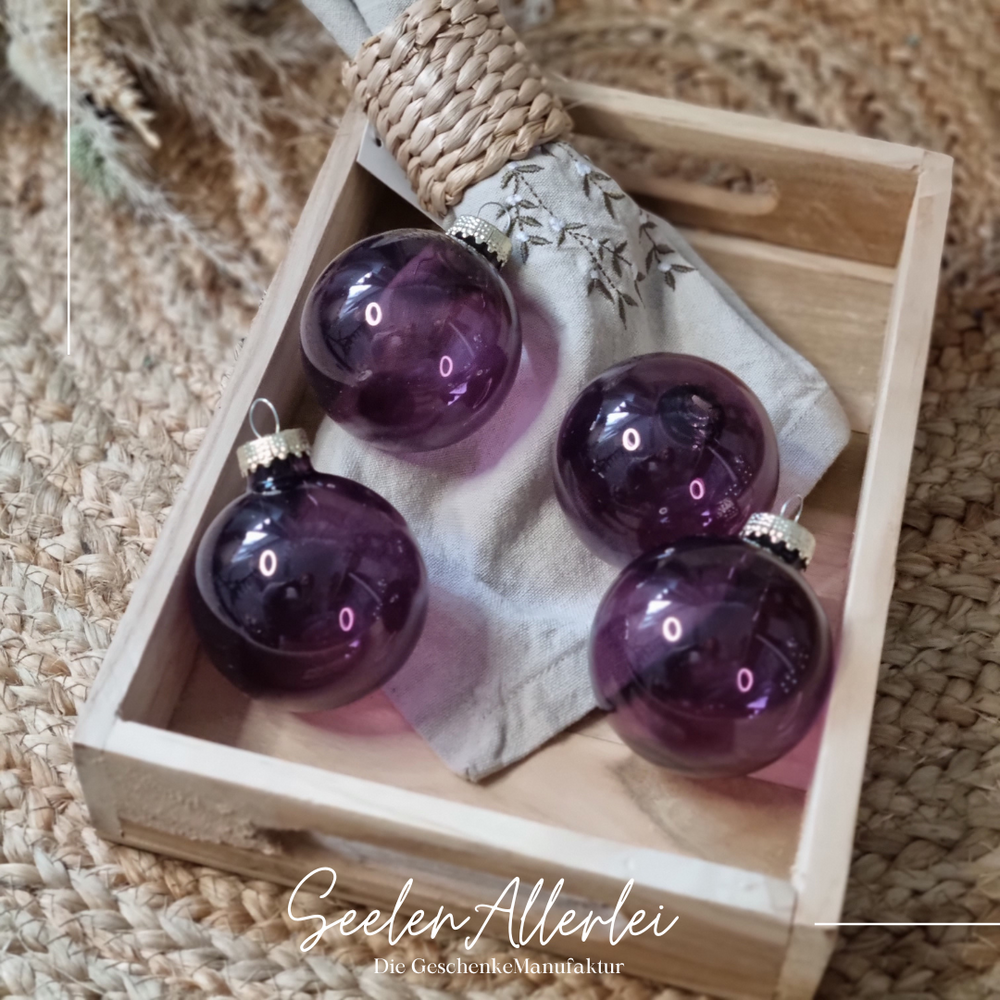 lila Weihnachtsbaumkugeln liegen auf einem Tablett