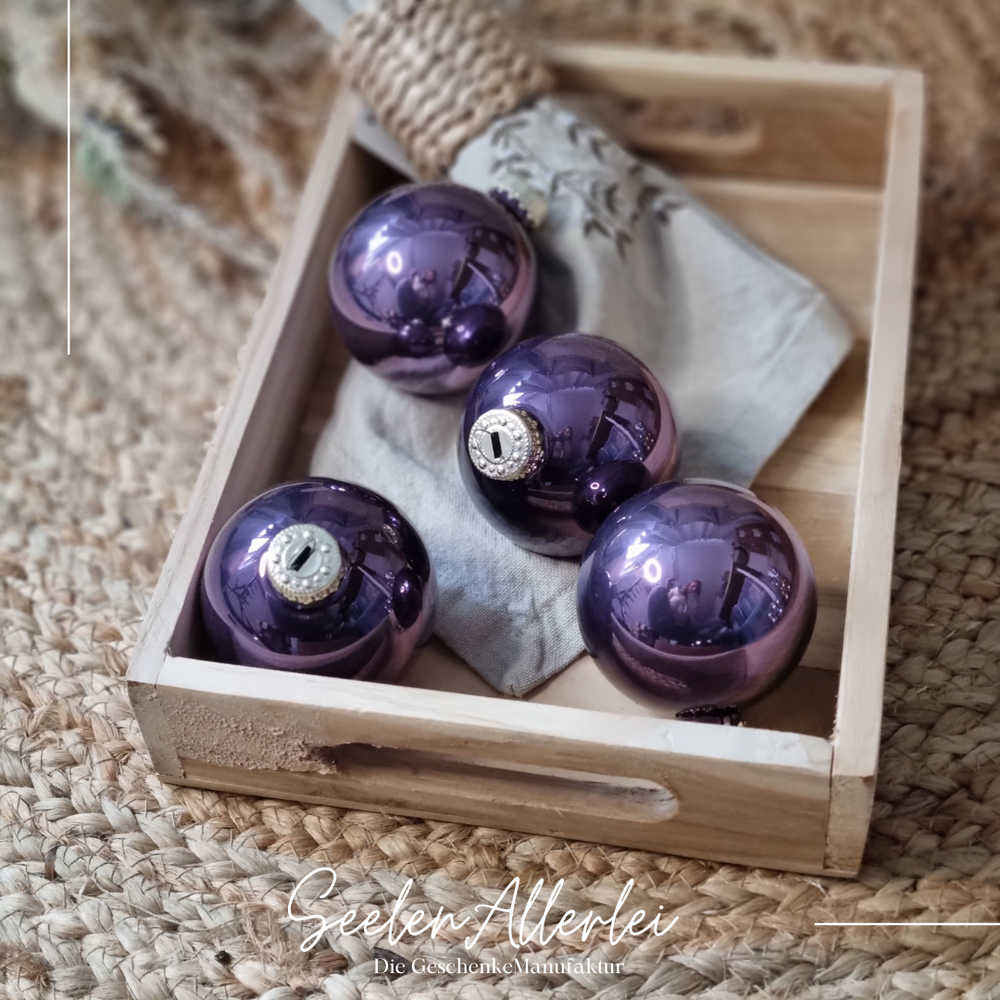 lila glänzende Weihnachtsbaumkugeln lieben auf einem Tablett