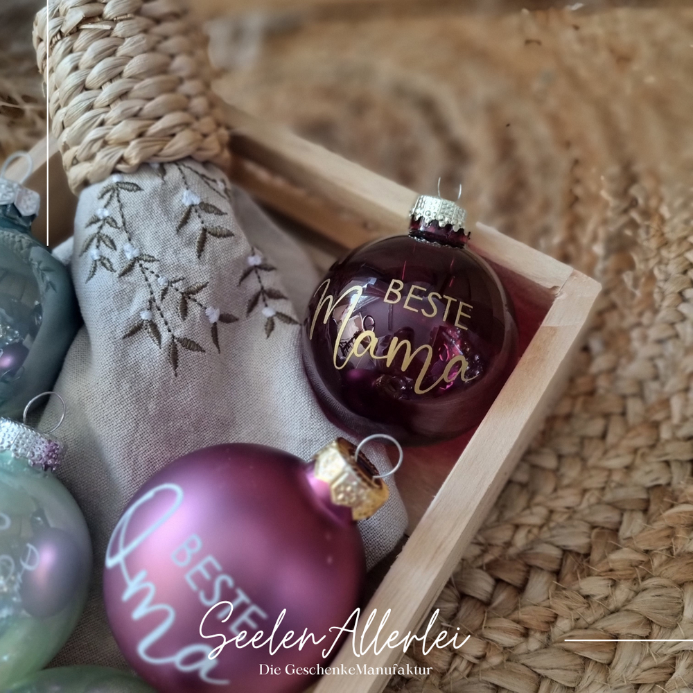 Dunkelrote klare Weihnachtsbaumkugel mit der Aufschrift Beste Mama