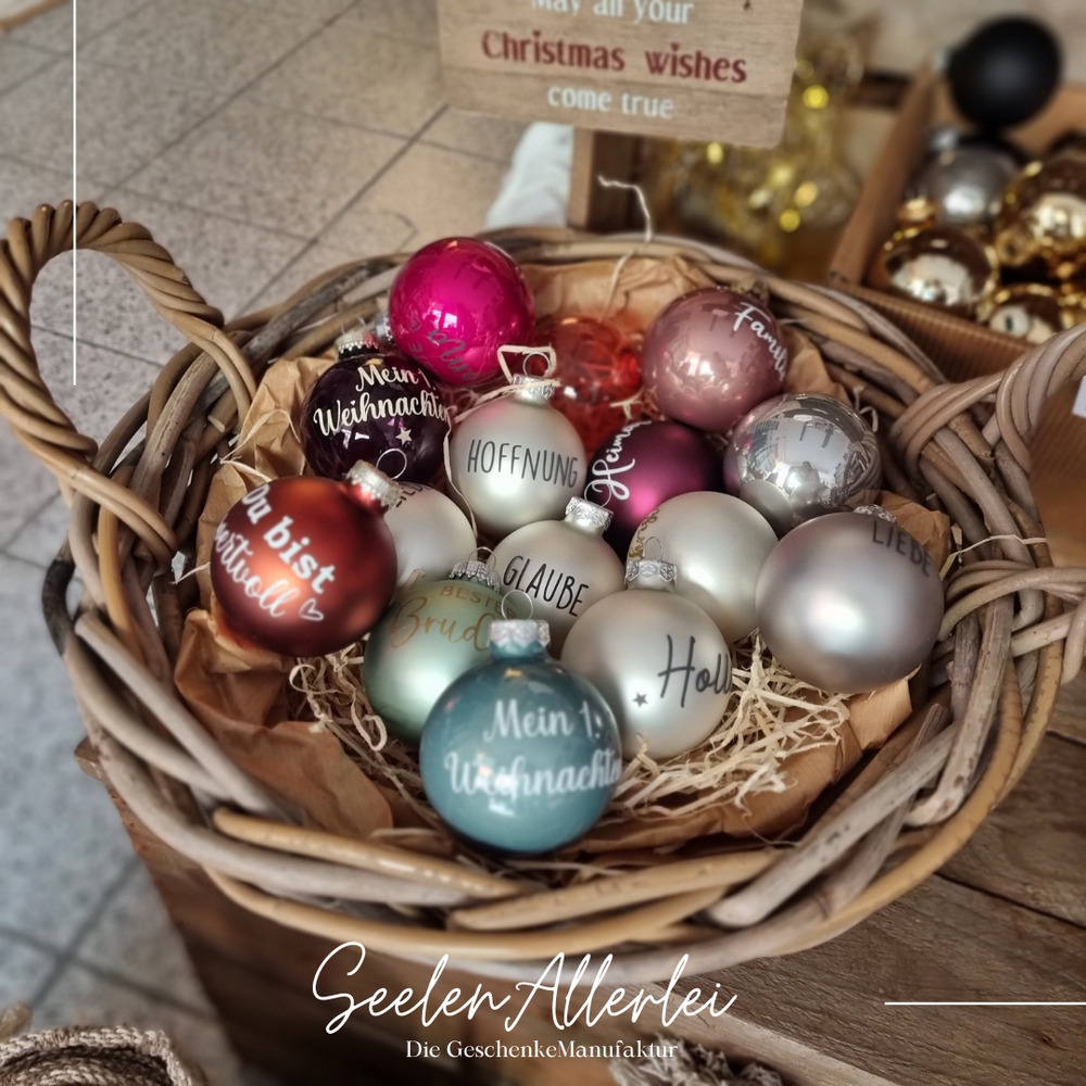 Korb voller Beispiel-Weihnachtsbaumkugeln mit verschiedenen Aufschriften
