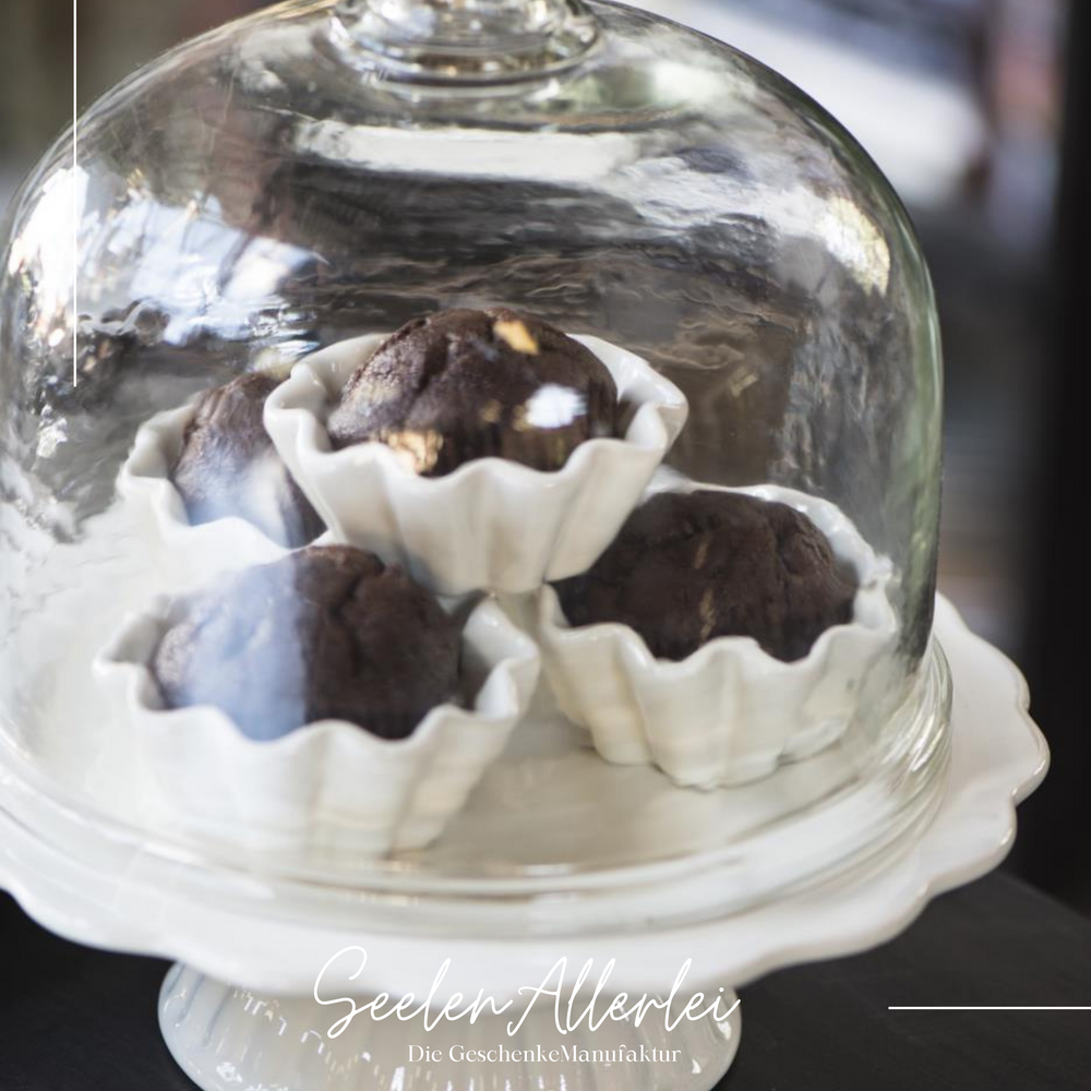 Butter Cream Tortenplatte von IB Laursen mit 4 Schokoladenmuffins unter einer Glashaube steht auf einem Holztisch
