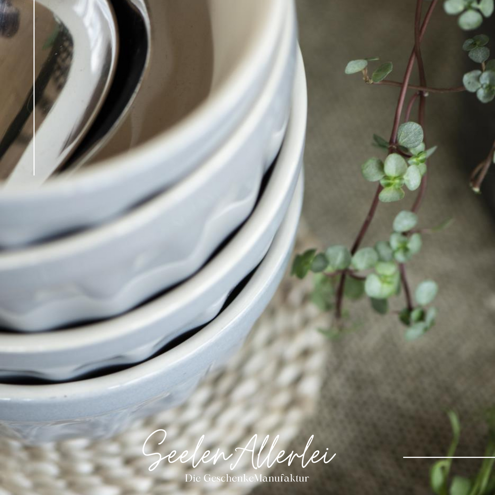 Nahaufnahme von oben von Schalen aus Keramik im Rillendesign die ineinander gestapelt auf einem Tisch stehen