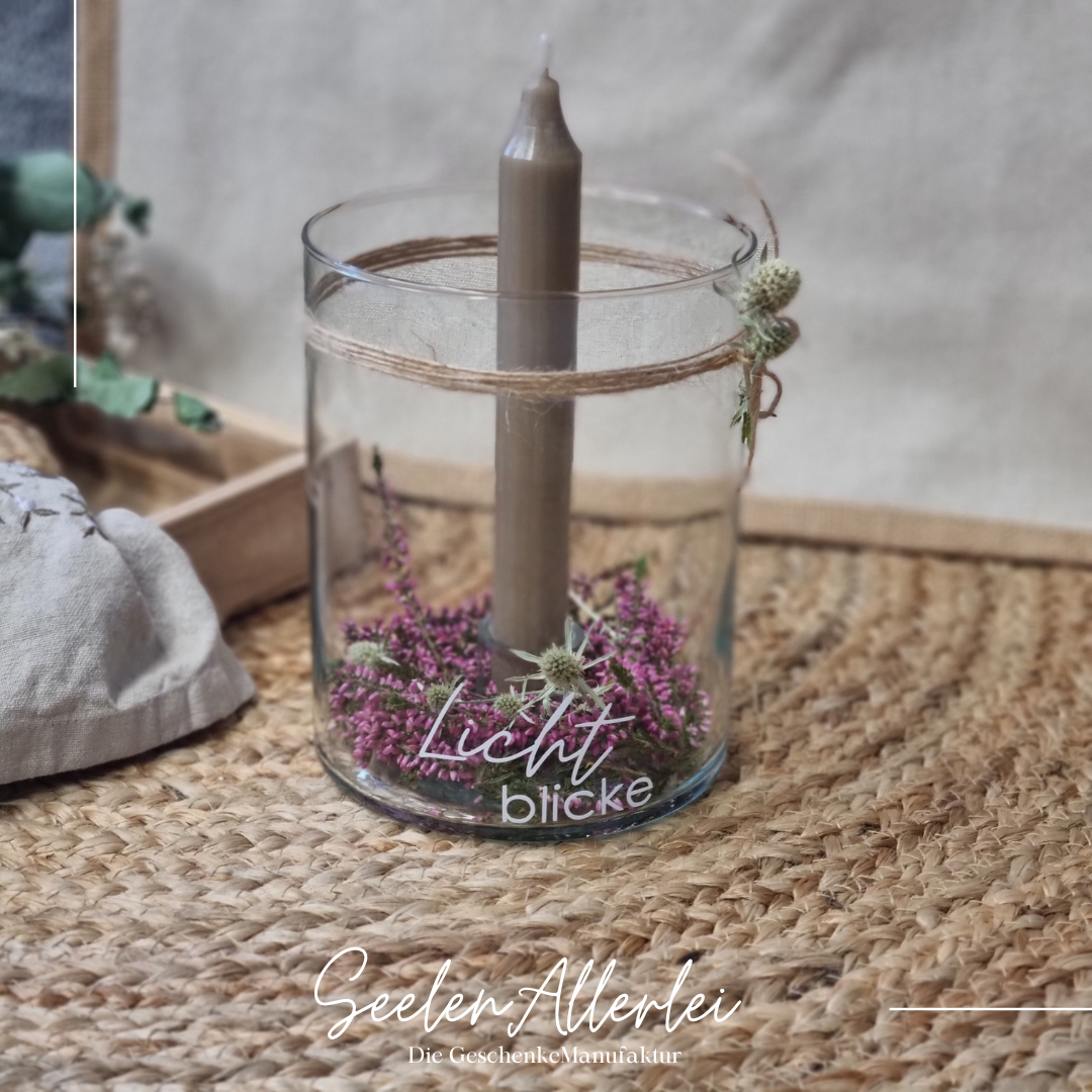 großes Kerzenglas mit brauner Stabkerze und wundervoller Dekoration aus Heide und Trockenblumen