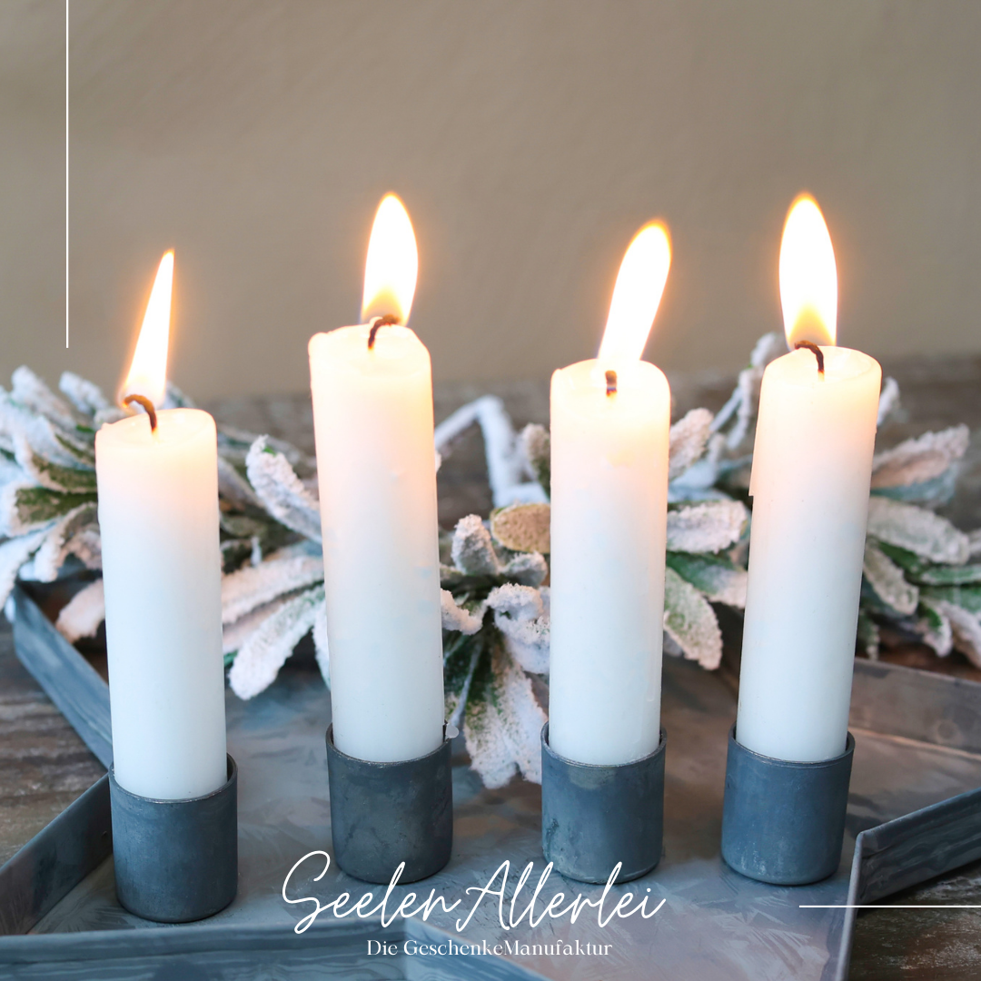 Einzelaufnahme tablett in Sternform mit 4 brennenden Kerzen und magnetischen Kerzenhaltern als Adventsarrangement steht auf einem Holztisch