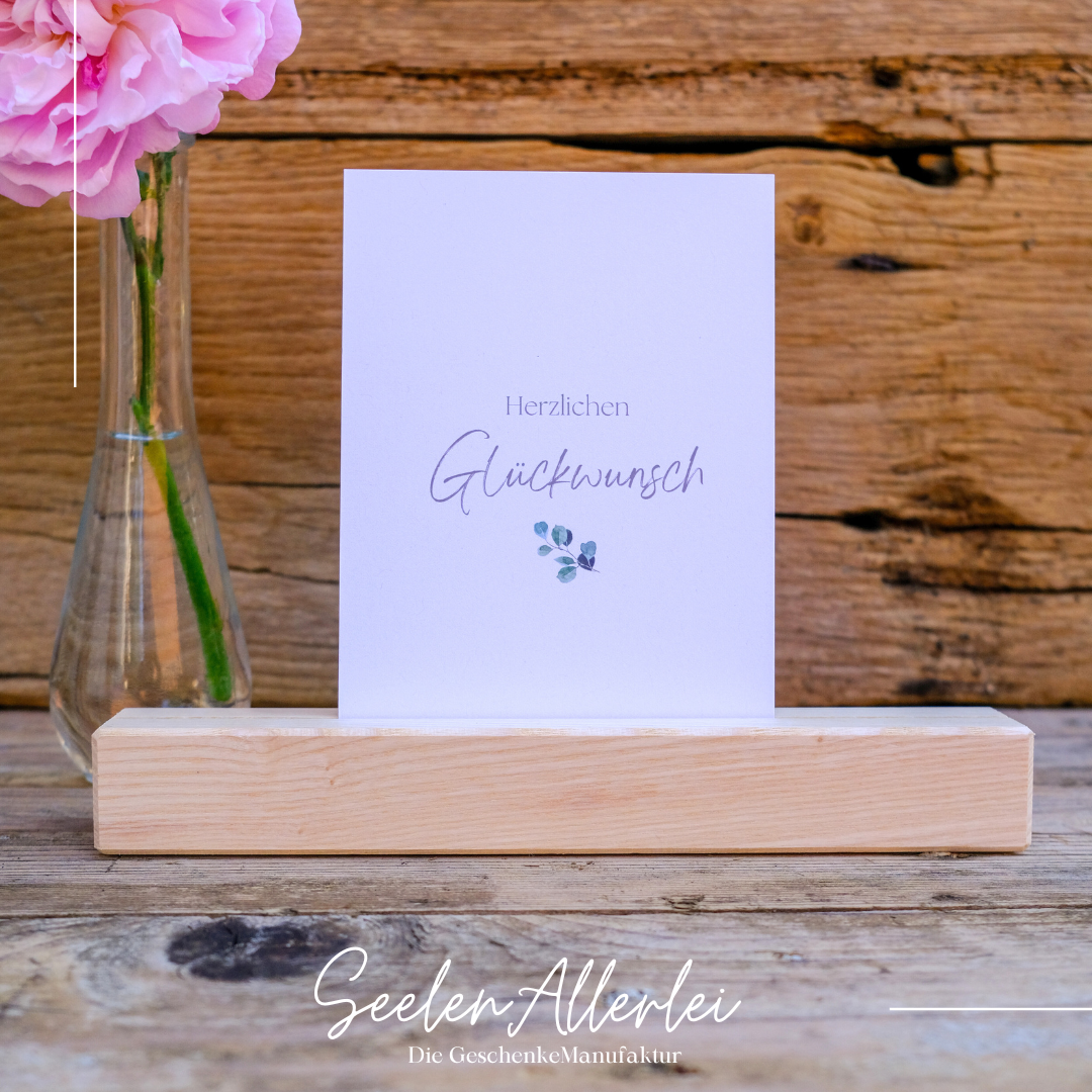 glückwunschkarte mit Herzlichen Glückwunch drauf steht in einem Kartenhalter aus Holz