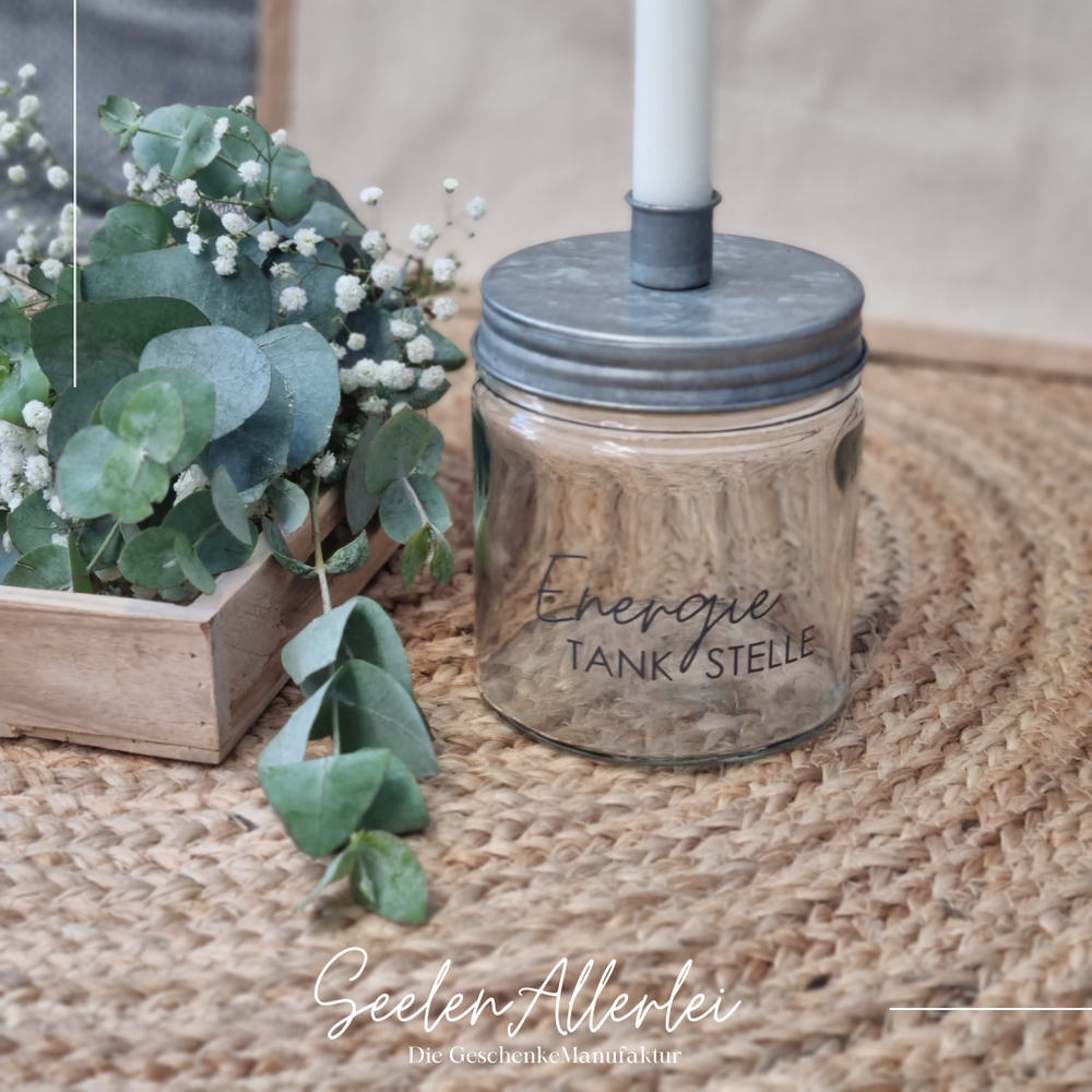 "Energietankstelle" steht auf einem Kerzenglas mit Metalldeckel