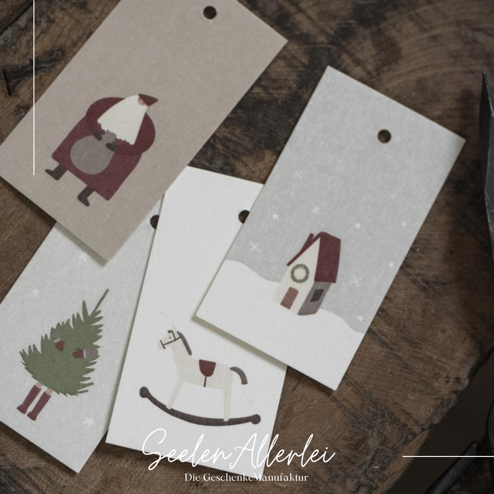 Detailaufnahme von 4 der Geschenkanhänger, die auf einem Holztisch liegen