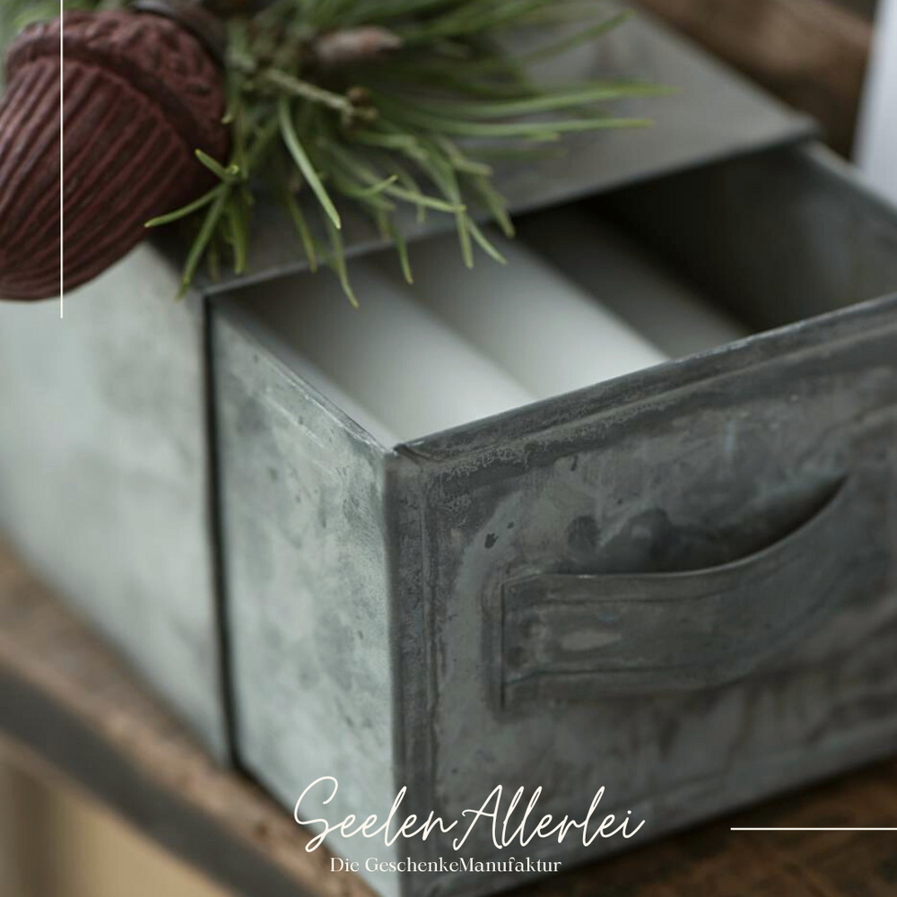 Detailaufnahme der Schublade gefüllt mit weißen Kerzen.