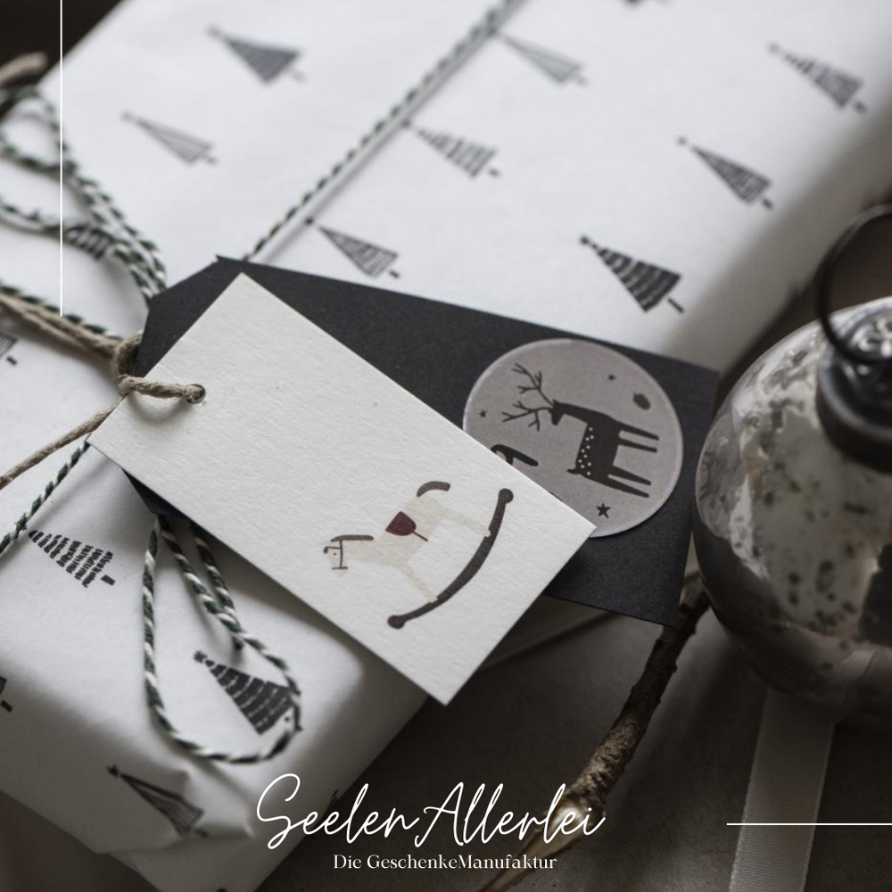 Beispielfoto von 2 Geschenkanhänger, die an ein schön eingepacktes Weihnachtsgeschenk gebunden wurden.