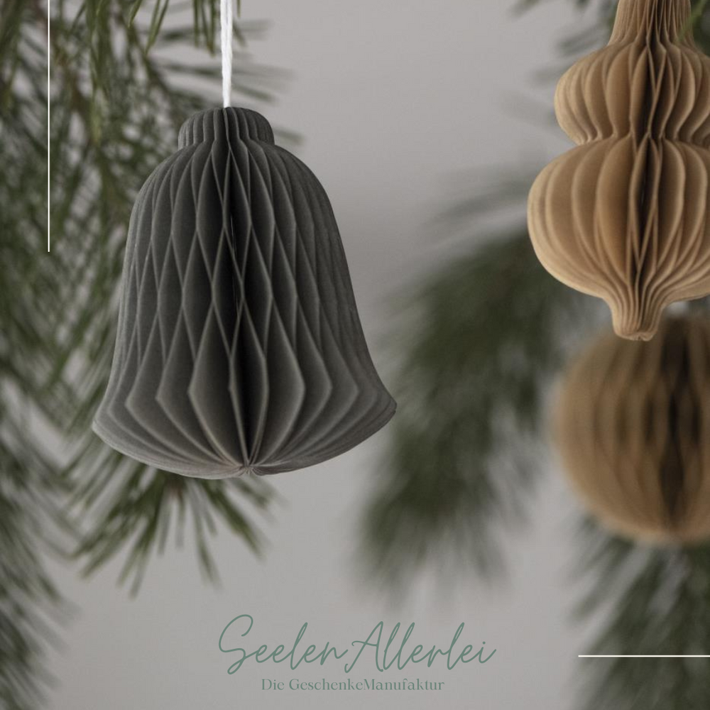 Glocke als Papieranhänger für den Weihnachtsbaum in Detailaufnahme, hintergrund verschwommen