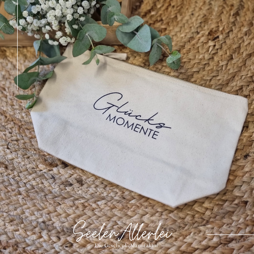 Kulturtasche naturfarbend mit der Aufschrift Glücksmomente in blau