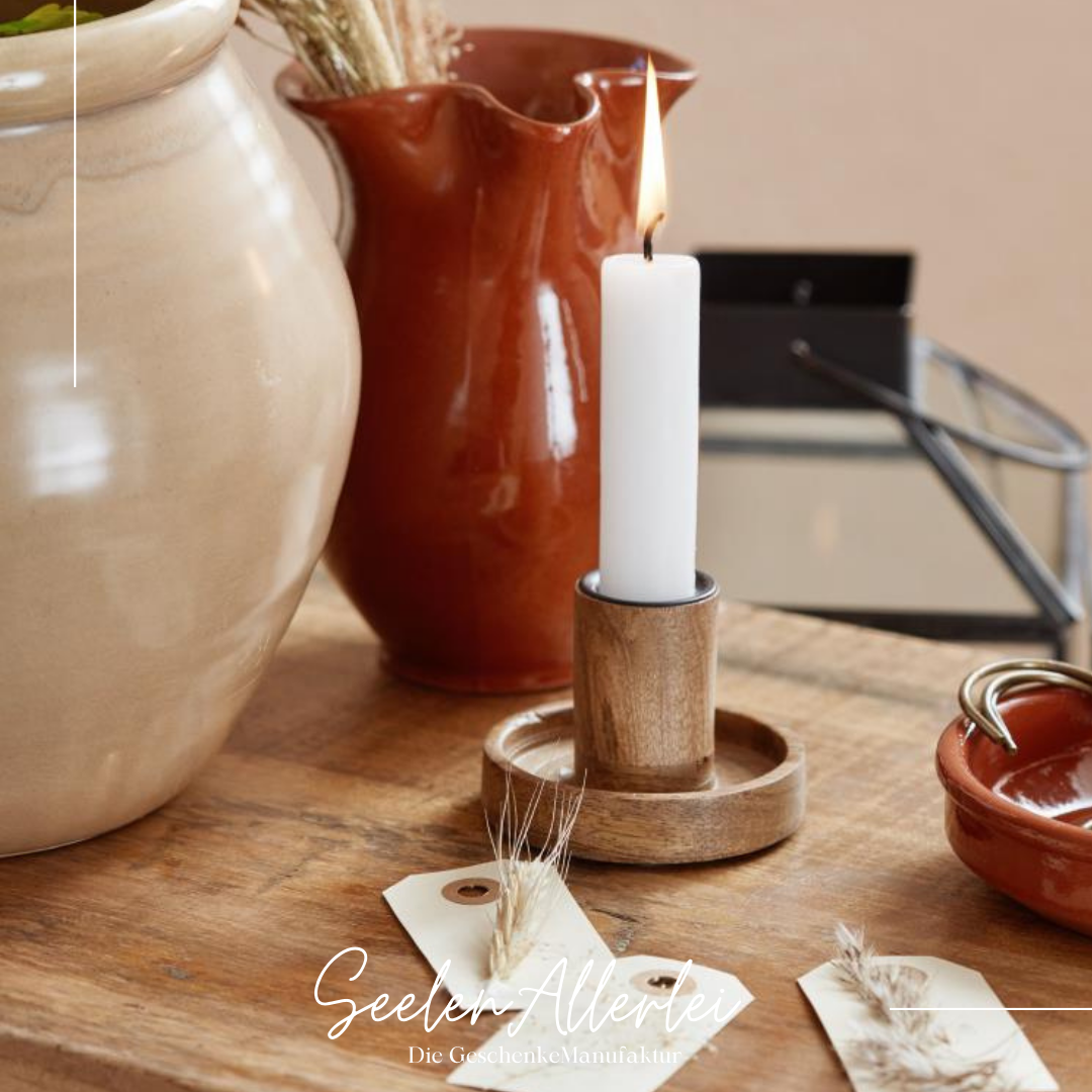 Wunderschöner Holz kerzenständer aus Mangoholz mit einer brennenden Kerze auf einem Holztisch dekoriert mit Vasen und Blumen