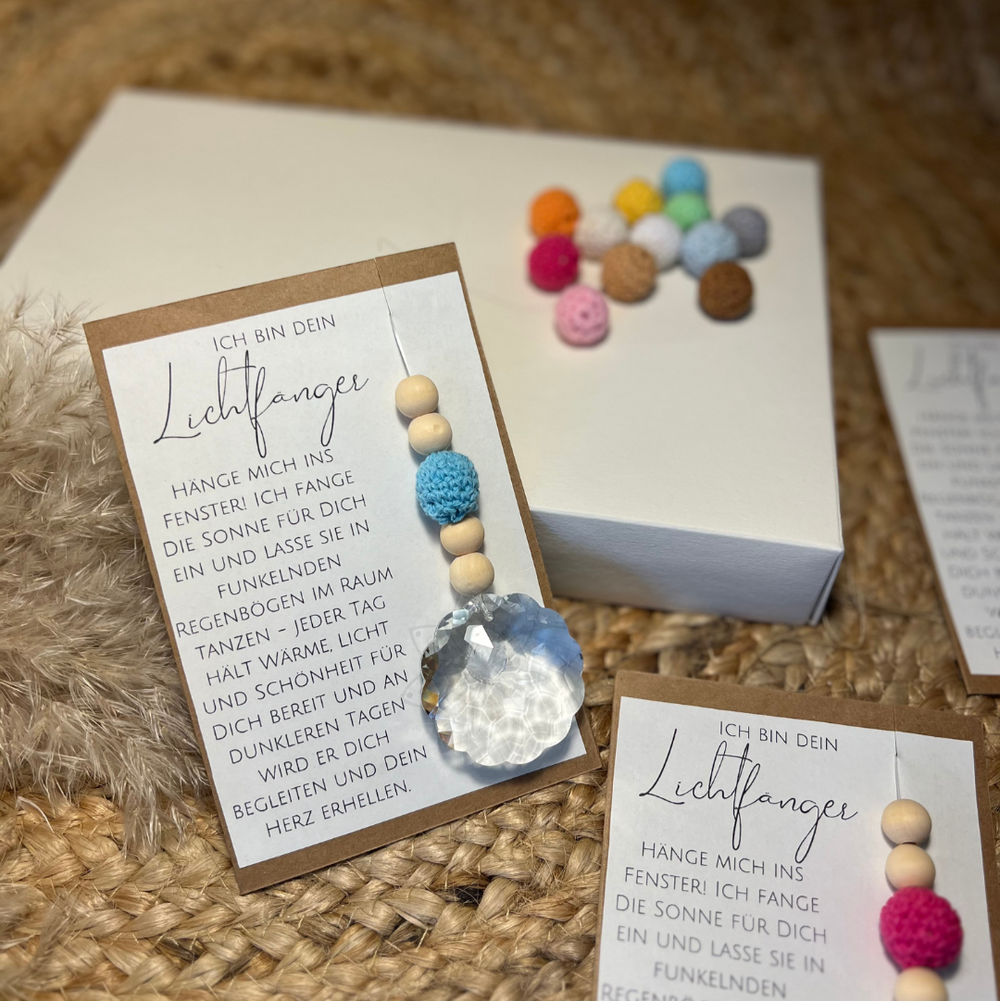 Suncatcher Lichtfänger in Geschenkverpackung. Eine Karte mit wundervollem Text und dem Anhänger mit Kristallkugel, blauer Häkelperle und Holzperlen.