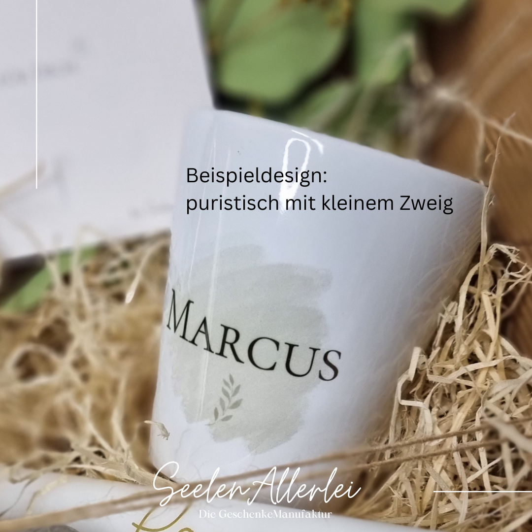 Detailaufnahme des Beispieldesigns für eine puristisch gestaltete personalisierte Tasse mit einem Namen Marcus und einem kleinen Zweig. Die Tasse liegt in einer Geschenkschale mit Holzwolle.