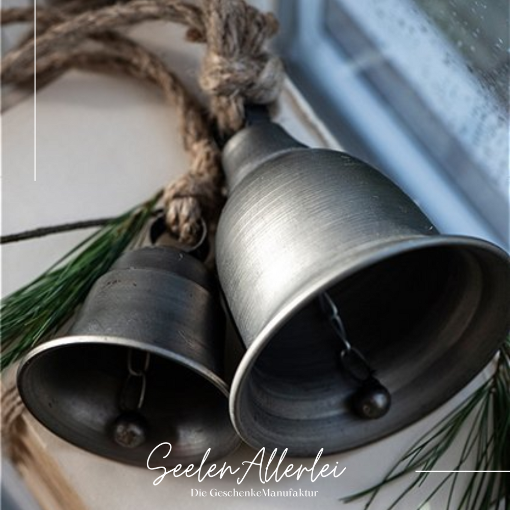 Glocke klein und groß aus Metall von IBLaursen liegen auf einer Fensterbank zur Dekoration