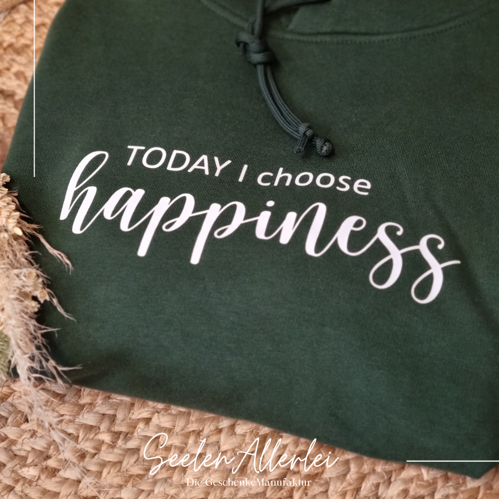 Dunkelgrüner Hoodie mit weißem Aufdruck TODAY I choose happiness auf natürlichem Untergrund mit Trockenblumen
