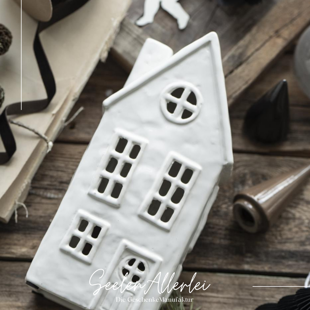 Weißes Keramikhaus für Teelicht mit rundem Fenster im eleganten skandinavischen Design