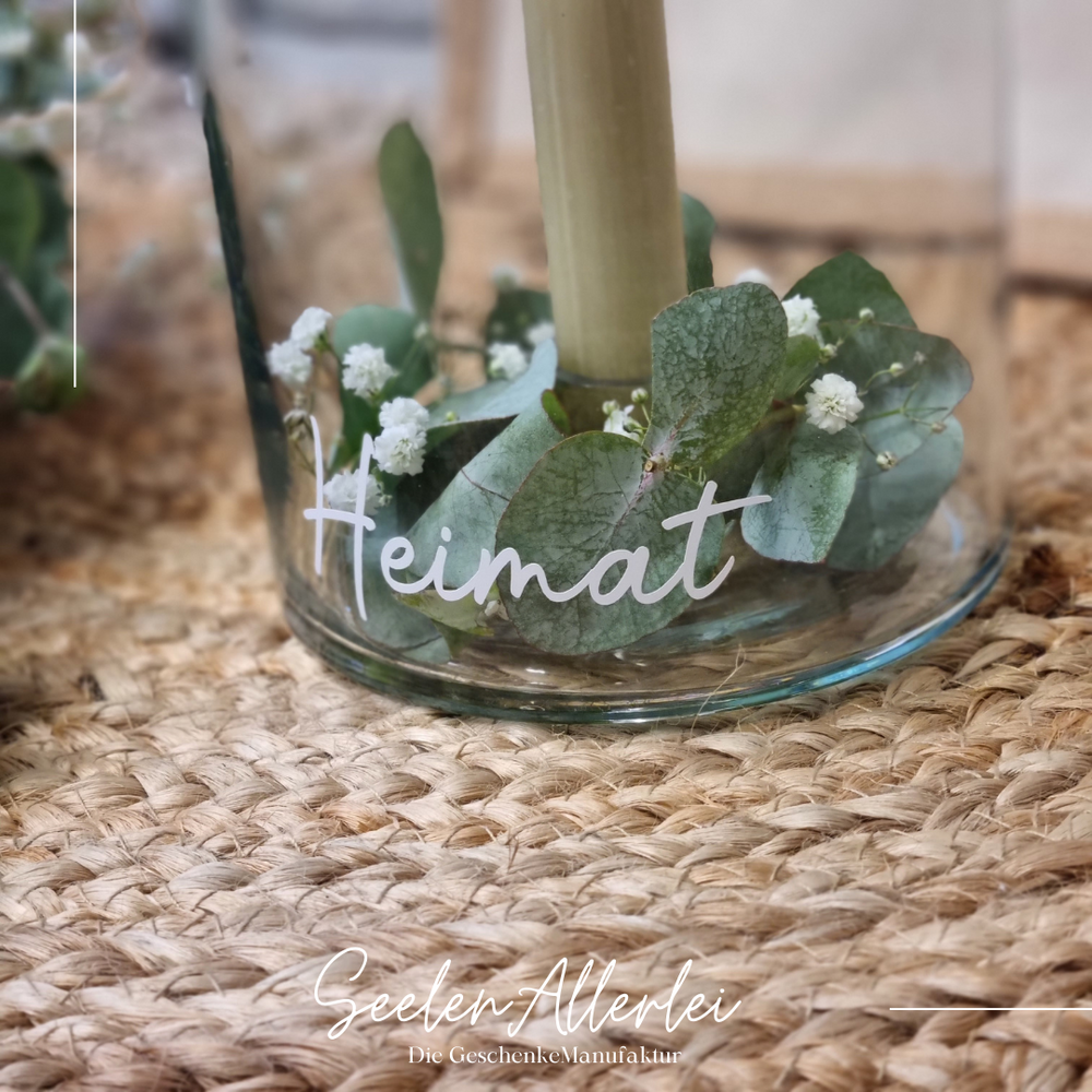 Nahaufnahme der Gravur Heimat auf personalisiertem Kerzenglas mit Eukalyptus-Dekoration