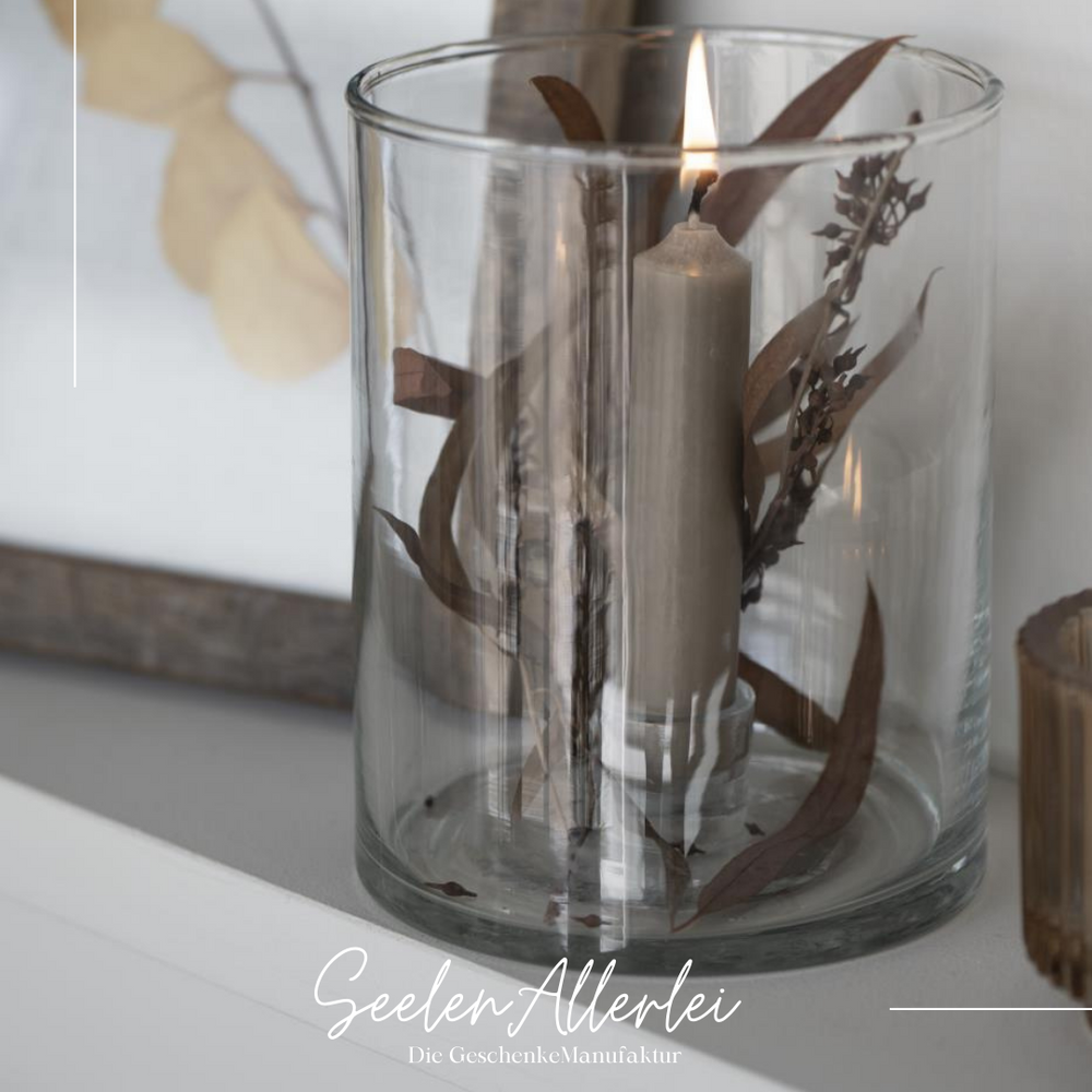 Windlicht mit getrockneten Pflanzen und brennender Kerze, natürliche Herbstdekoration im Glas