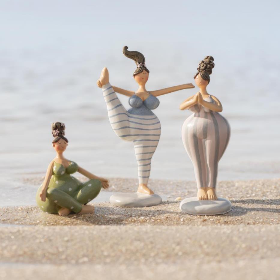 Yoga Figuren von Iblaursen stehen am Strand in unterschiedlichen Farben und Yogapositionen.