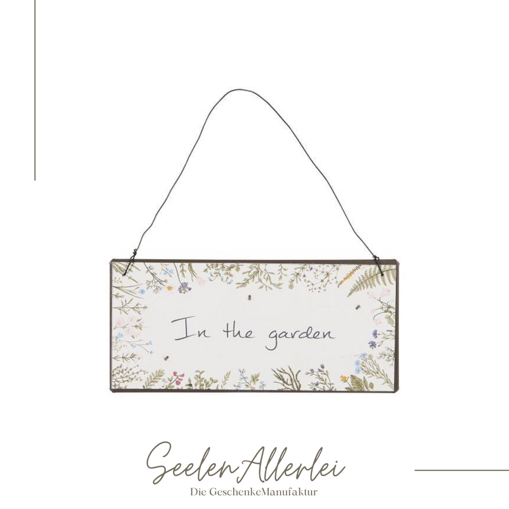 Schild zum Hängen aus Metall mit Drahtaufhängung vor weißem Hintergrund mit der Aufschrift in the garden
