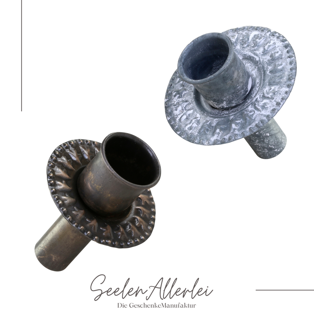 zwei Kerzenhalter aus messing und aus zink vor weißem Hintergrund